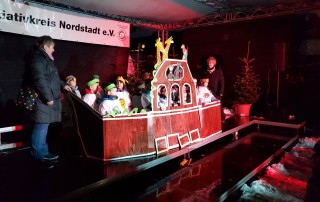 Singspiel der Kinder des Familienzentrums Marienburg auf einer Bühne auf dem Neusser Weihnachtsmarkt.