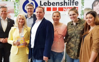 Gruppenfoto von Mitarbeiterinnen der Lebenshilfe Neuss, dem Geschäftsführer Winfried Janßen sowie Landrat Hans-Jürgen Petrauschke, Bürgermeisterin Gisela Hohlmann und Veranstalter Frank Küpping auf der messe "Kinder, Kinder" am Stand der Lebenshilfe Neuss.
