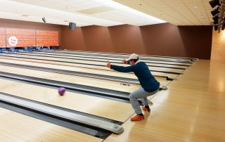 Eine UWO-Nutzerin der Lebenshilfe Neuss wirft eine Bowlingkugel auf einer Bowlingbahn.