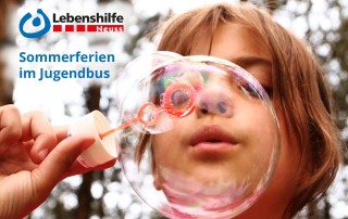 Nahe Ansicht eines Kindes das Seifenblasen macht. Oben befindet sich das Logo der Lebenshilfe Neuss. Darunter der Schriftzug: "Sommerferien im Jugendbus".