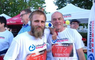 Zwei Teilnehmer des Firmenlaufs in T-Shirts der Lebenshilfe Neuss.