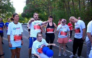 Eine Gruppe Teilnehmer der Lebenshilfe Neuss beim Firmenlauf, inklusive einer Person im Rollstuhl.