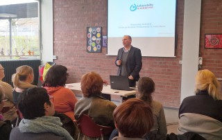 Ein Mann redet vor einem Publikum bei einem Vortrag zum Bundesteilhabe Gesetz.