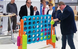 Besucher der Kinder, Kinder Messe spielen bei einem großen Vier-gewinnt Spiel am Lebenshilfe Stand.