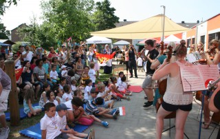 Kinder sehen dem Auftritt des Orchesters beim Sommerfest der Lebenshilfe Neuss zu.
