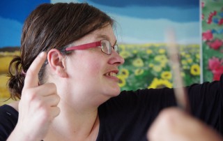 Porträt einer Frau die redet und gestikuliert.
