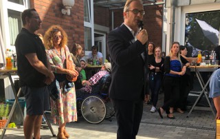 Ein Mann spricht bei der Eröffnung in ein Mikrofon.