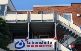 Ein großes Banner hängt am Wohnhaus der Lbenshilfe Neuss in der Theresienstraße.