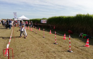 Ein Kind und ein Erwachsener nehmen an einem kleinen sportlichen Wettkampf auf dem Familienfest im Dycker Feld teil.