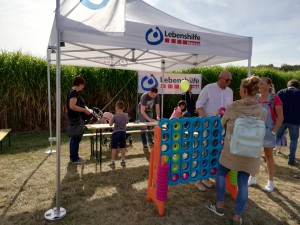 Mitarbeitende und Besucher stehen am Stand der Lebenshilfe Neuss.
