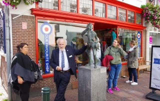 Mitarbeitder der Lebenshilfe Neuss stehen bei Stadtführung in Roermond vor einer Statue.