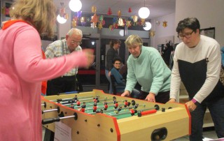 Vier Uwo-Nutzer spielen Tisch-Kicker.