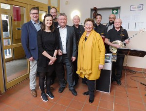Angelika Quiring-perl, WInfried Janßen und Hermann Gröhe stehen mit Mitarbeitenden und Musikern für ein Gruppenbild zusammen.