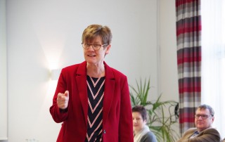 Porträt von Prof. Dr. Antje Britta Mörstedt während sie einen Vortrag vor Mitarbeitenden der Lebenshilfe Neuss hält.