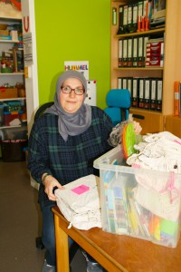 Eine Mitarbeiterin sortiert Material an einem Tisch.