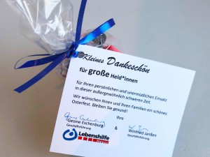 Ein kleines Geschenktütchen mit einem Zettel daran befestigt, auf dem ein Dank der Geschäftsführer der Lebenshilfe Neuss steht.