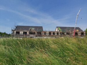 Der Neubau des Kinder- und Jugendwohnhauses des Lebenshilfe Neuss e.V. in Allerheiligen mit einem Feld davor.