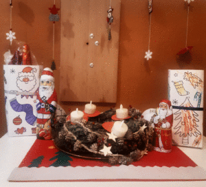 Ein Adventskranz umgeben von Weihnachtsdeko.