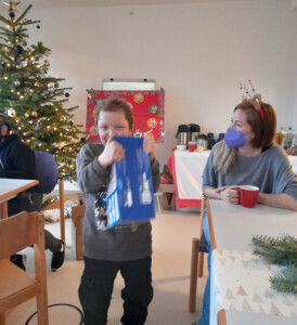Ein Kind hält freudig das Geschenk in der Hand.