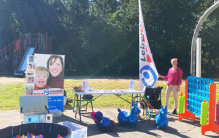 Ein Bild vom Stand der Lebenshilfe Neuss mit verschiedenen Spielen und einem Tisch.