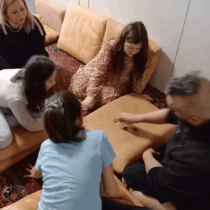 Drei Kinder und zwei Erwachsene spielen zusammen.