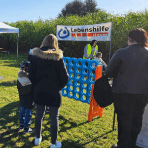 Ein Kind und eine Frau stehen vor dem Spiel Vier Gewinnt.