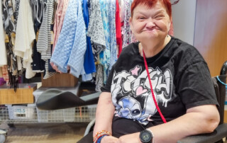 Eine Frau ist vor einem Kleider-Ständer