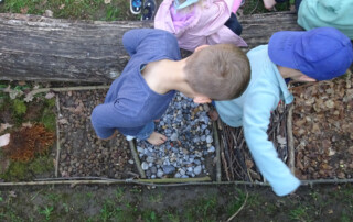 Kinder laufen über einen Barfuß-Pfad.