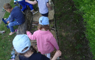 Kinder laufen über einen Barfuß-Pfad.