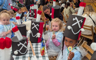 Mehrere Kinder halten ihre Medaillen in die Kamera.