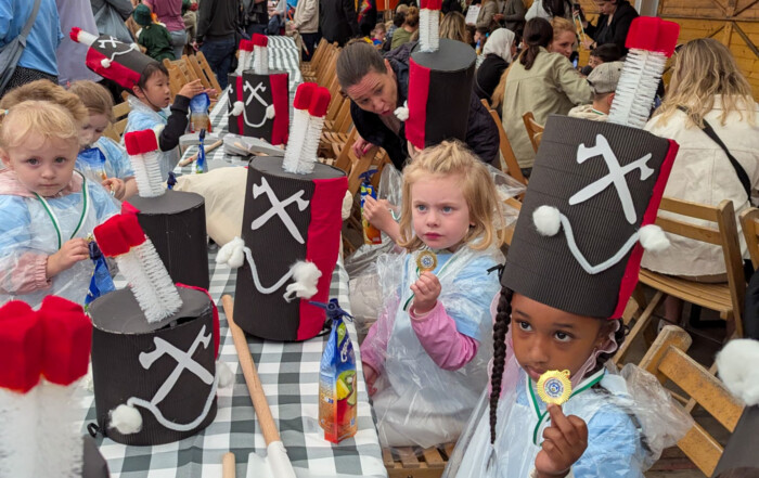 Mehrere Kinder halten ihre Medaillen in die Kamera.