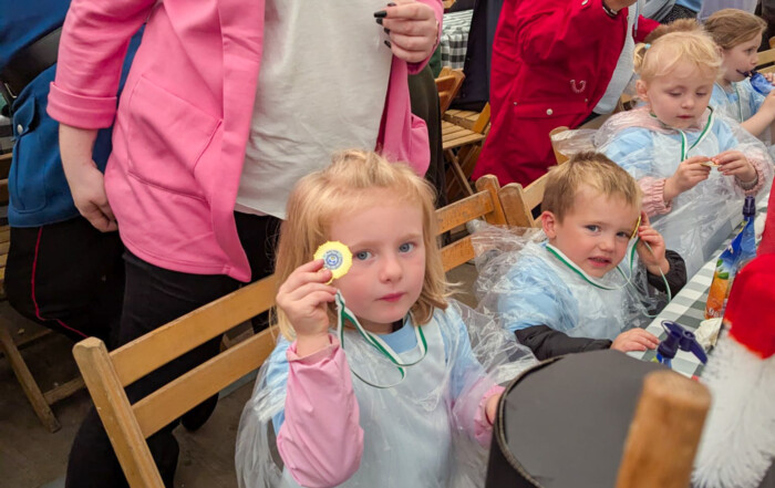 Ein Mädchen hält ihre Medaille in die Kamera.