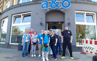 Die Reisenden stehen zusammen für ein Gruppenfoto vor dem Eingang der Unterkunft.