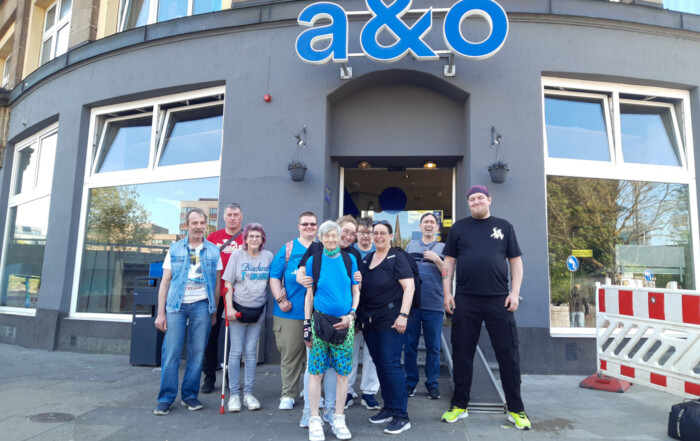 Die Reisenden stehen zusammen für ein Gruppenfoto vor dem Eingang der Unterkunft.