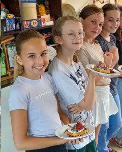 Mehrere Kinder stehen für ein Gruppenfoto zusammen.