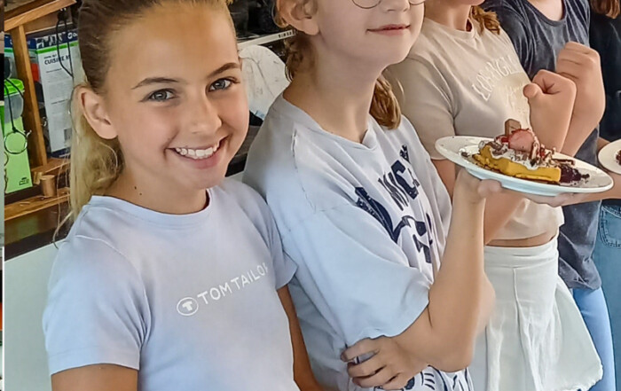 Mehrere Kinder stehen für ein Gruppenfoto zusammen.