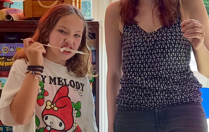 Ein Mädchen und eine Betreuerin kommen zusammen für ein Gruppenfoto.