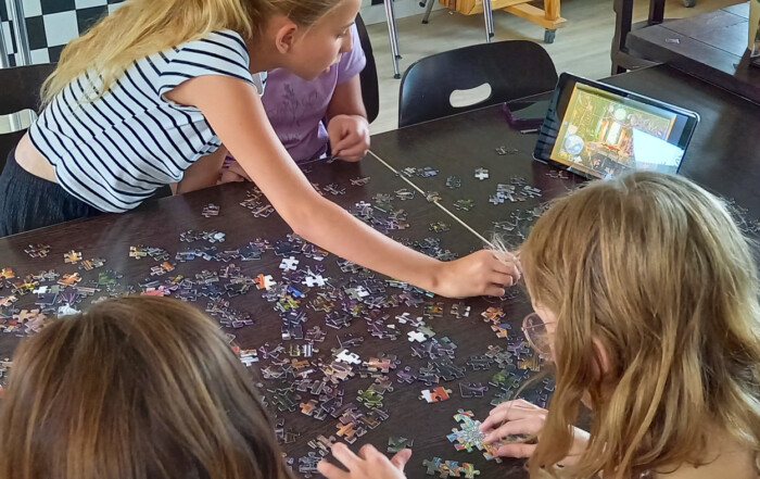 Mehrere Kinder spielen zusammen ein Puzzle.