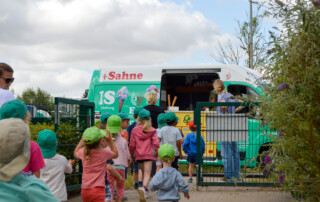 Mehrere Kinder stehen Schlange vor dem Eiswagen.