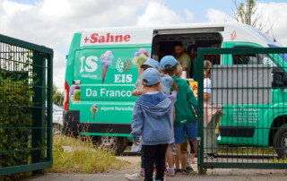Mehrere Kinder stehen Schlange vor dem Eiswagen.