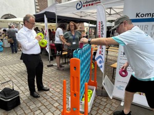 Mehrere Personen spielen das übergroße Vier-Gewinnt-Spiel.