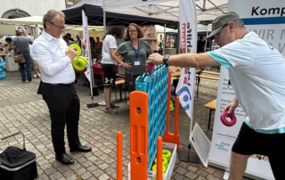 Mehrere Personen spielen das übergroße Vier-Gewinnt-Spiel.