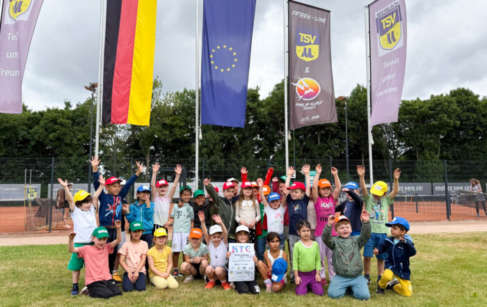 Ein Grupppenfoto der Teilnehmenden Kinder wie sie die Arme in die Luft werfen.