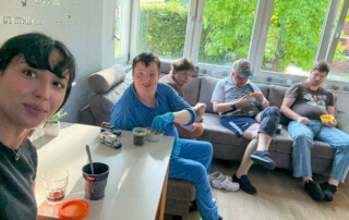 Mehrere Bewohner sitzen auf der Couch und schauen den Film an.