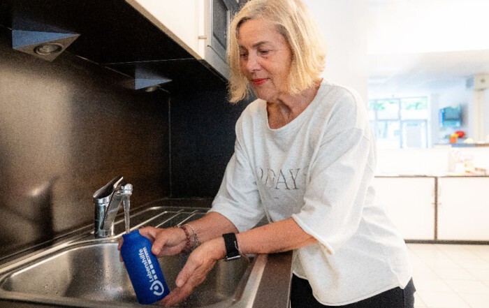 Eine Frau befüllt ihre Flasche mit Wasser.