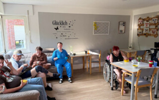 Mehrere Bewohner sitzen auf der Couch und schauen den Film an.