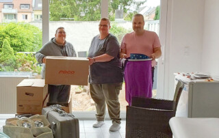 Drei Personen packen Umzugskisten