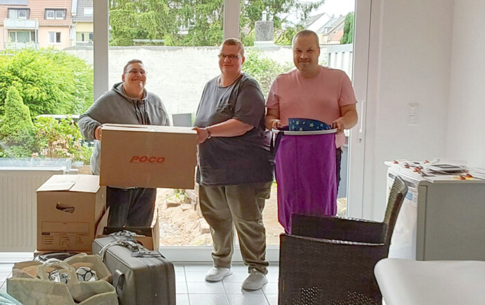 Drei Personen packen Umzugskisten