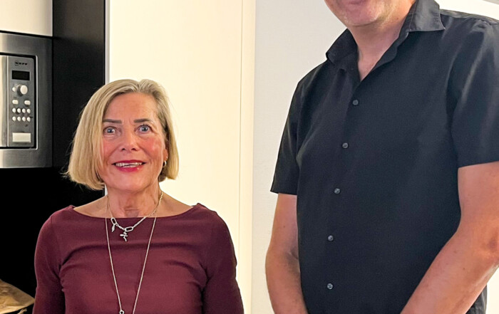 Zwei Personen lächeln in die Kamera.