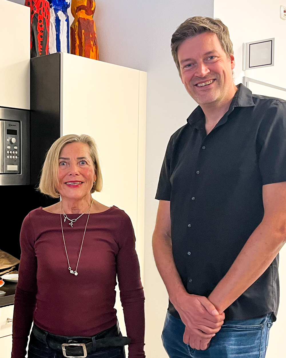 Zwei Personen lächeln in die Kamera.